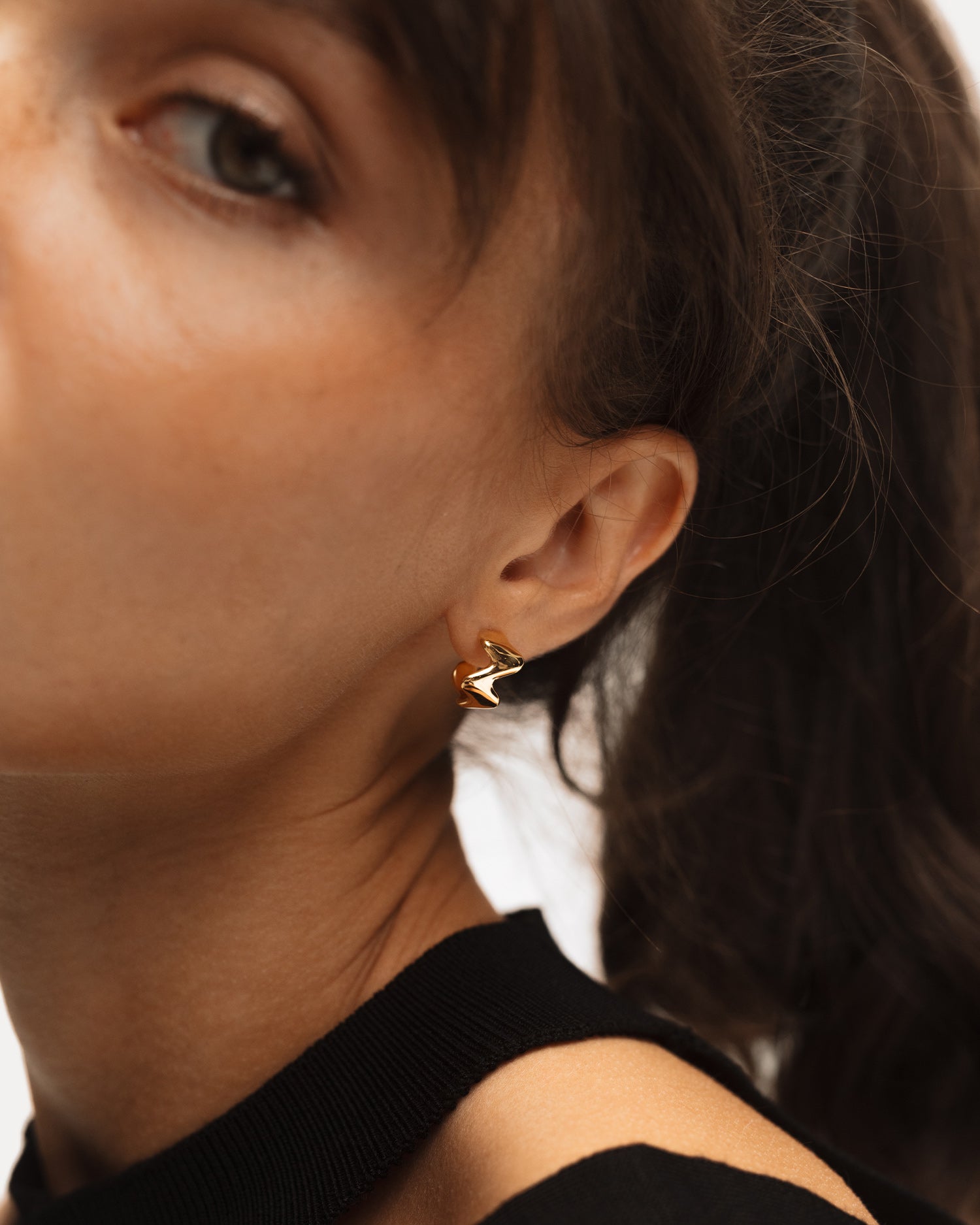 The POISE Huggie Hoops in 18k Gold Vermeil shown on the ear of a model - NATALIE GRASSI